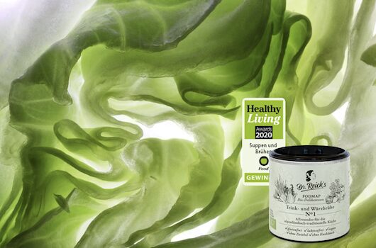 Dr. Reich's Brühe No.1 mit Healthy LIving Award vor angeschnittenem Eisbergsalat